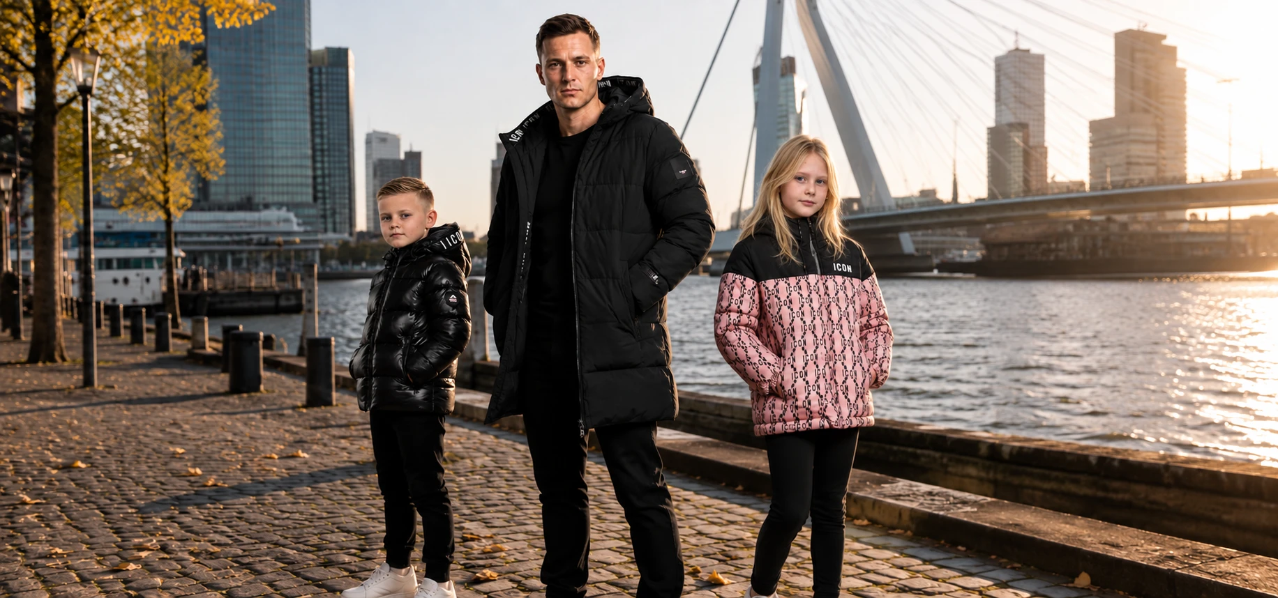 Man, jongen en meisje in ICON Original jassen bij de Erasmusbrug